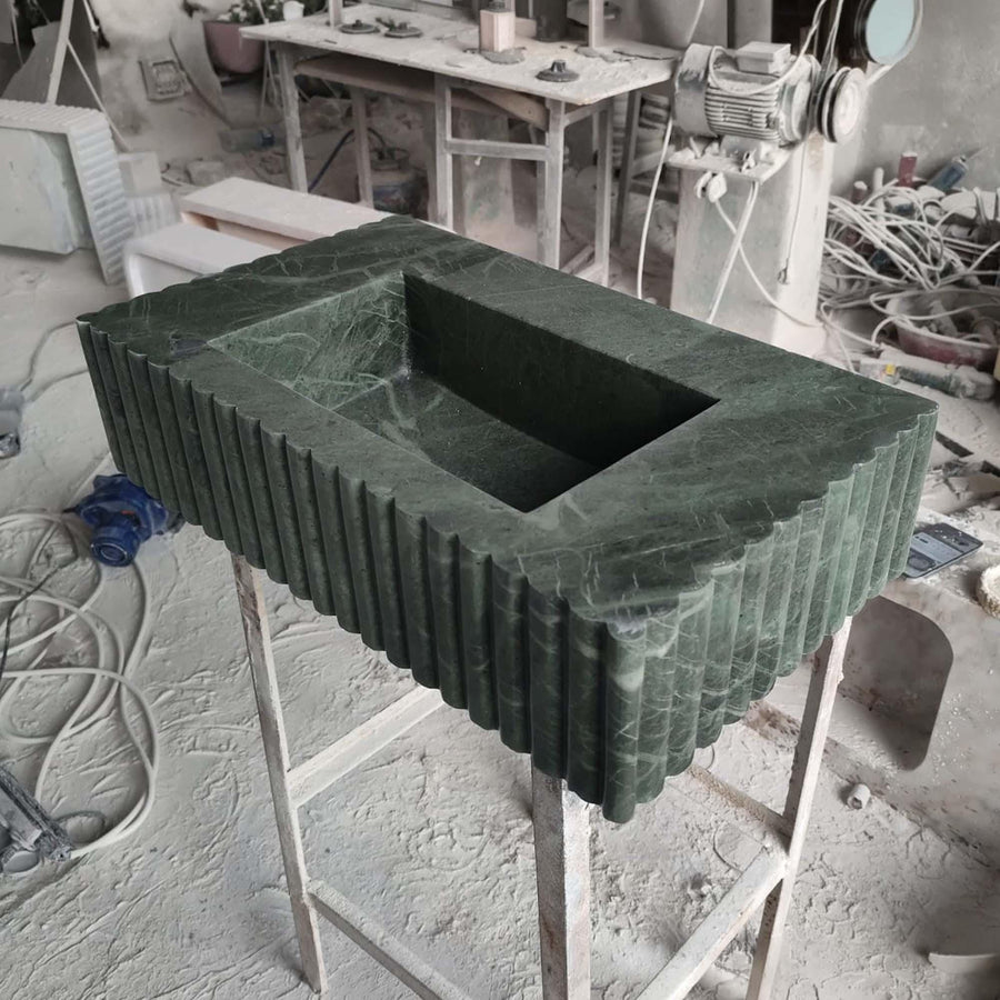 Handcrafted green marble console sink with deep rectangular basin and scalloped fluted apron