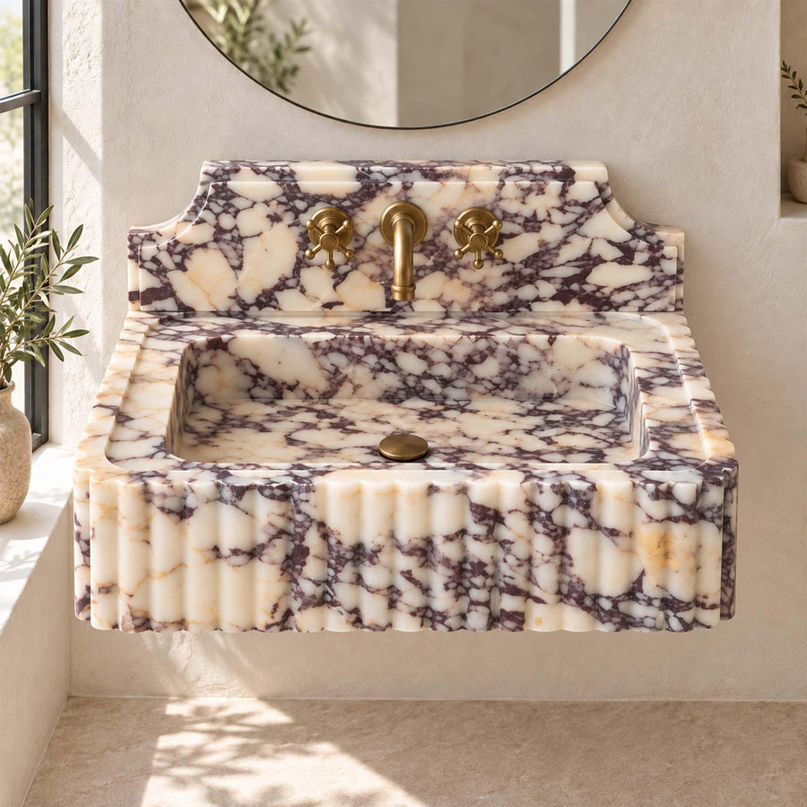 Side view of a solid Calacatta Viola fluted console sink