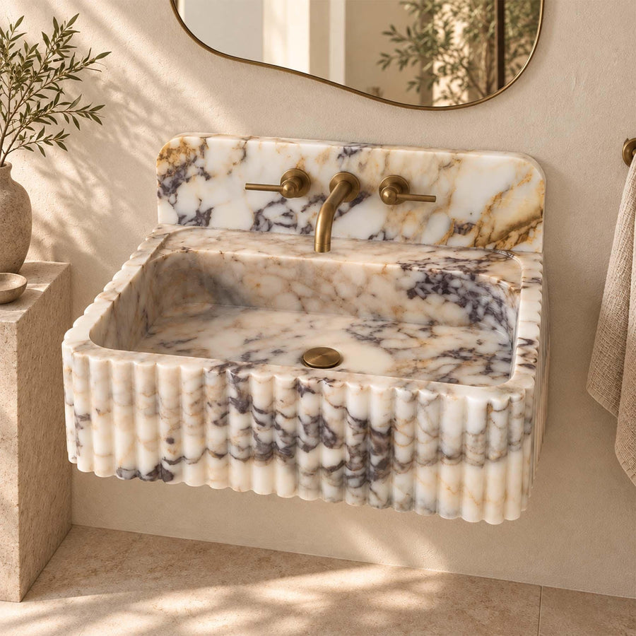 Natural stone fluted vanity sink in Calacatta Gold with brass fittings