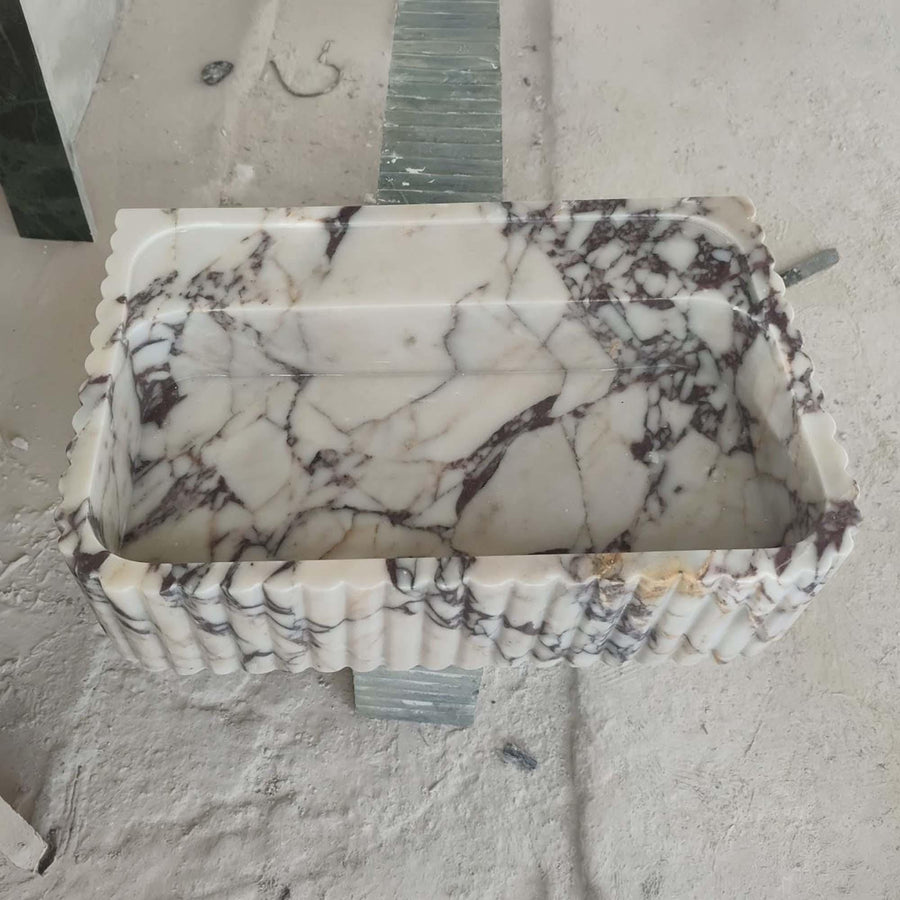 Natural stone fluted floating sink in Calacatta Viola with brass fittings