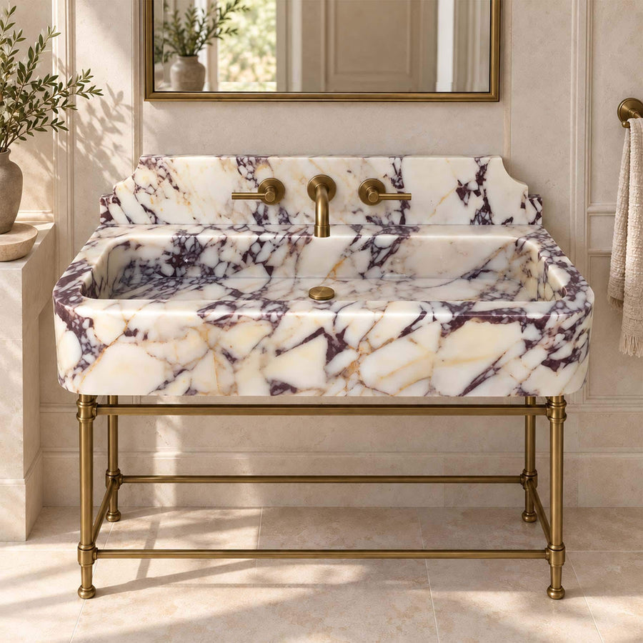 Calacatta Viola smooth console sink with decorative backsplash on a custom brass vanity stand