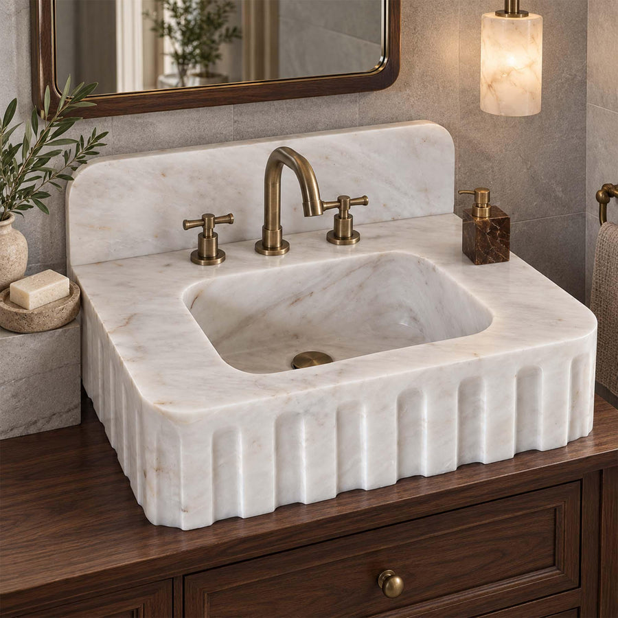 Natural stone fluted vanity sink in Carrara White with brass fittings