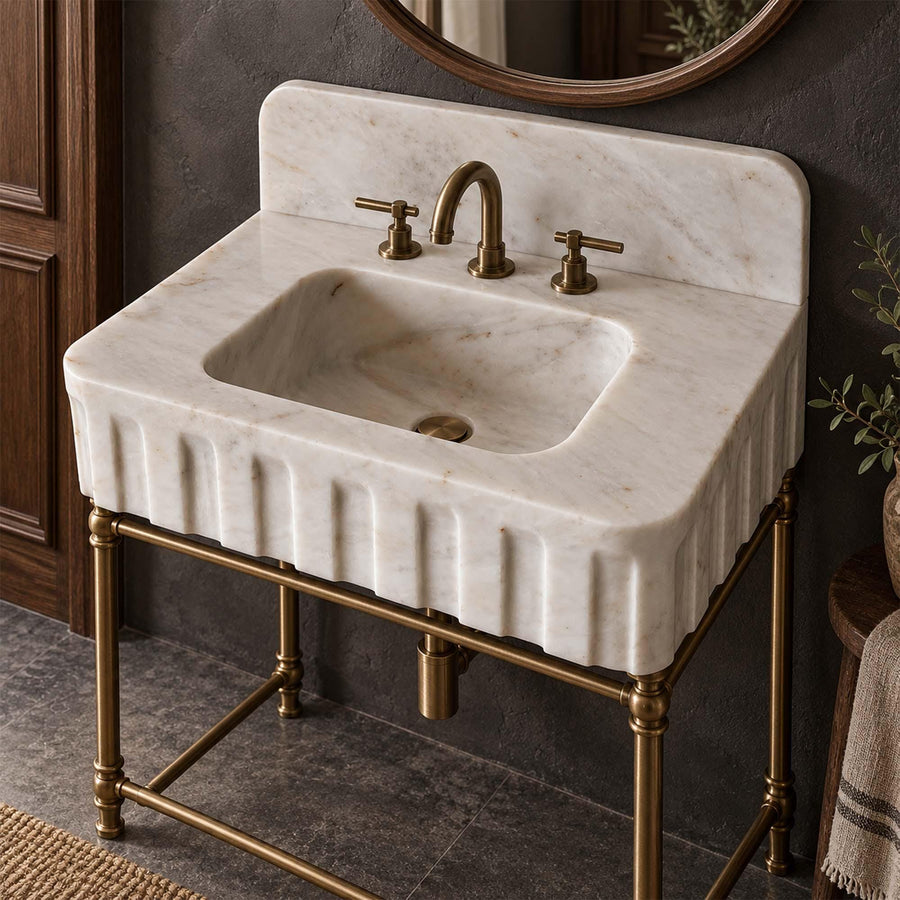 Carrara White fluted marble sink with rounded backsplash on a custom brass vanity stand