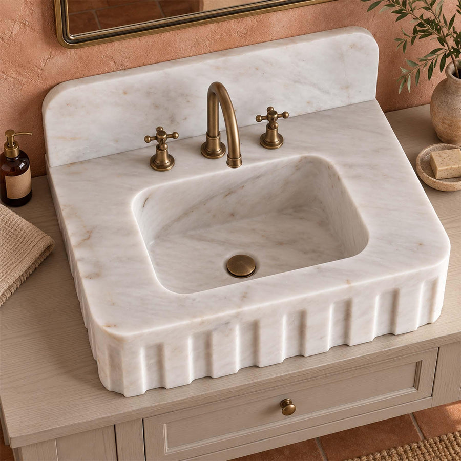 Carrara White fluted marble sink with rounded backsplash in a luxury bathroom