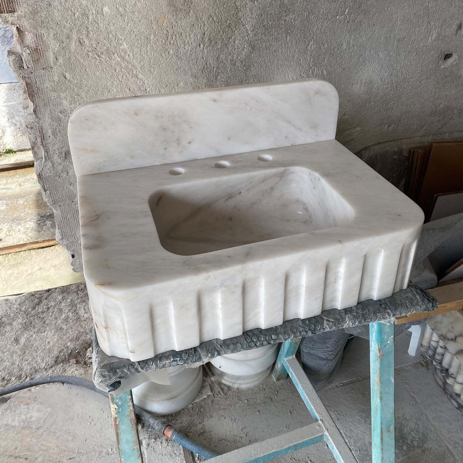 Carrara White fluted vanity sink showing the drilled faucet holes