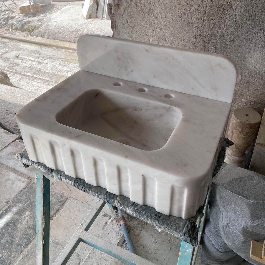 Close-up of natural veining on a Carrara White fluted vanity sink