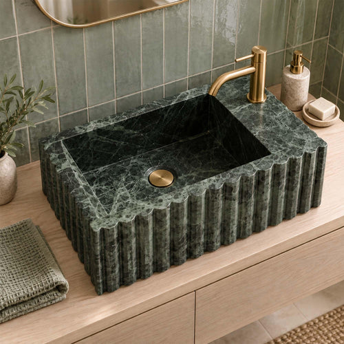 Green marble fluted vanity sink with single faucet hole in a luxury bathroom