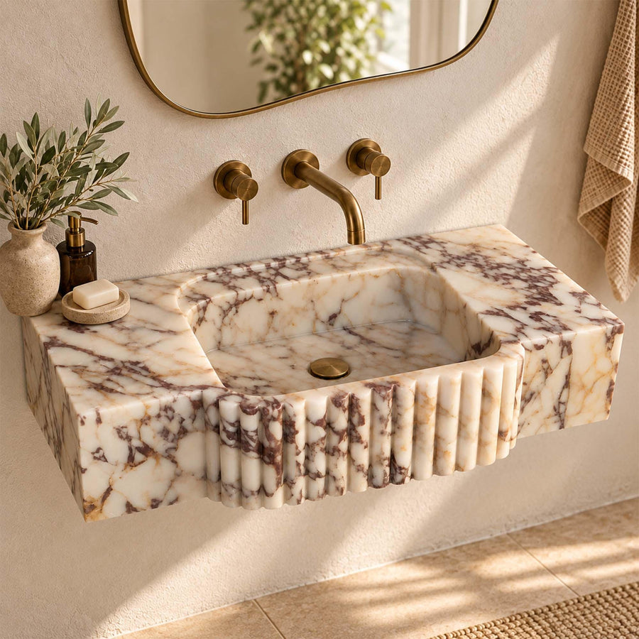 Calacatta Viola marble console sink with fluted center apron styled in a designer powder room
