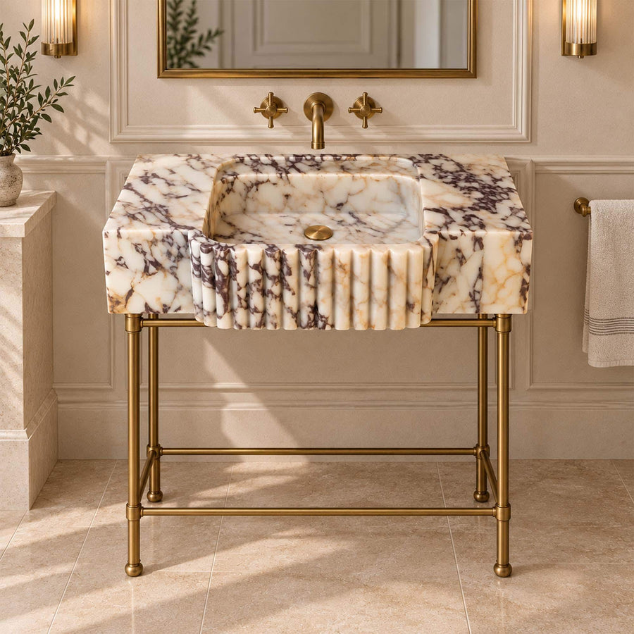Side view of a solid Calacatta Viola fluted apron console sink