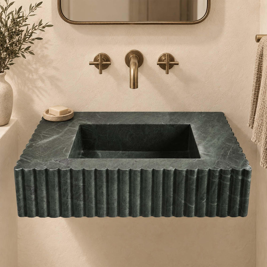 Green marble wall-mounted sink with fluted sides and antique brass faucet, front view