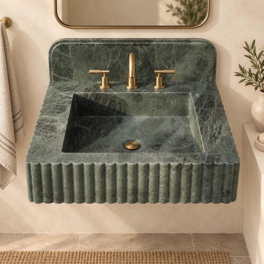 Close-up of green marble veining and vertical fluting on a custom bathroom sink