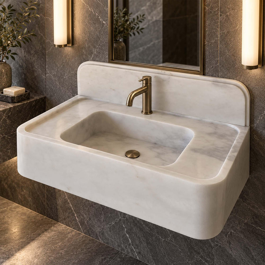 Angled view of a handcrafted Carrara White bathroom sink