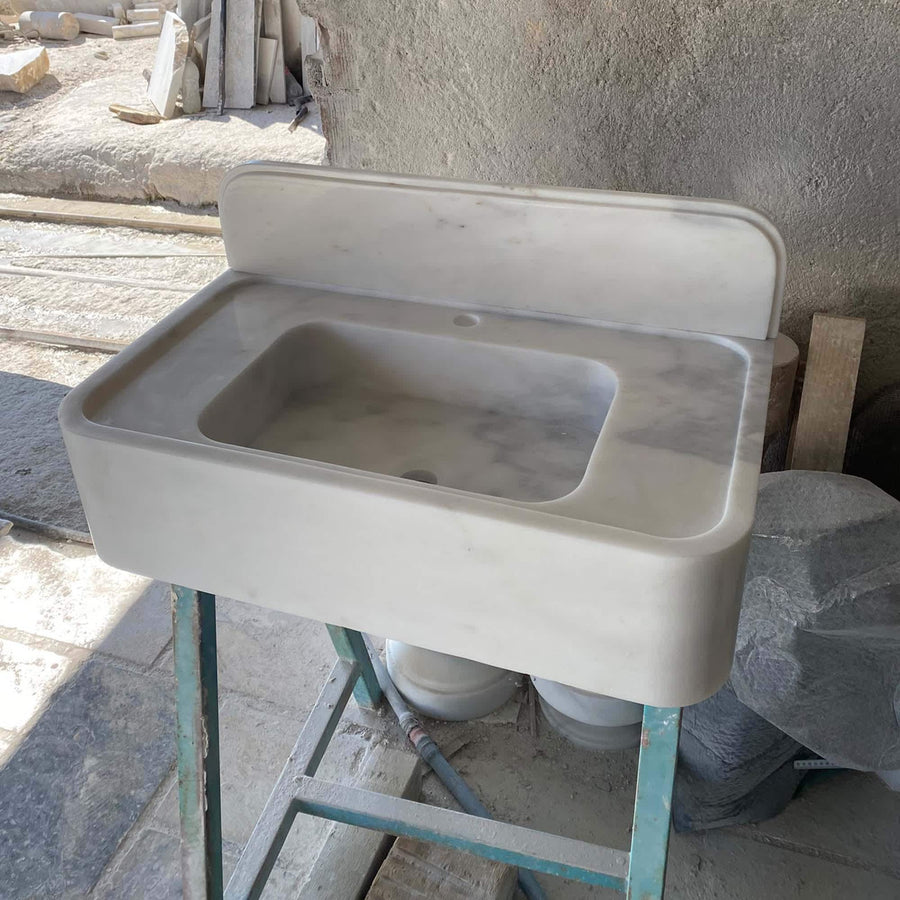 Side view of a solid Carrara White console sink