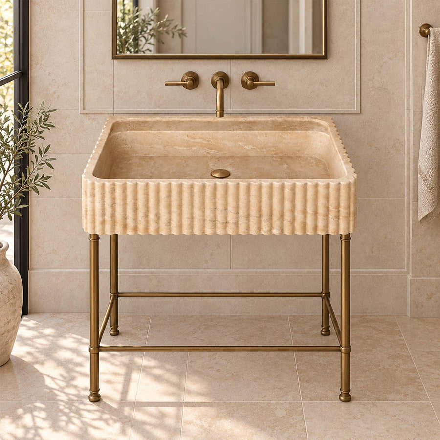 Beige travertine fluted console sink on a custom brass vanity stand