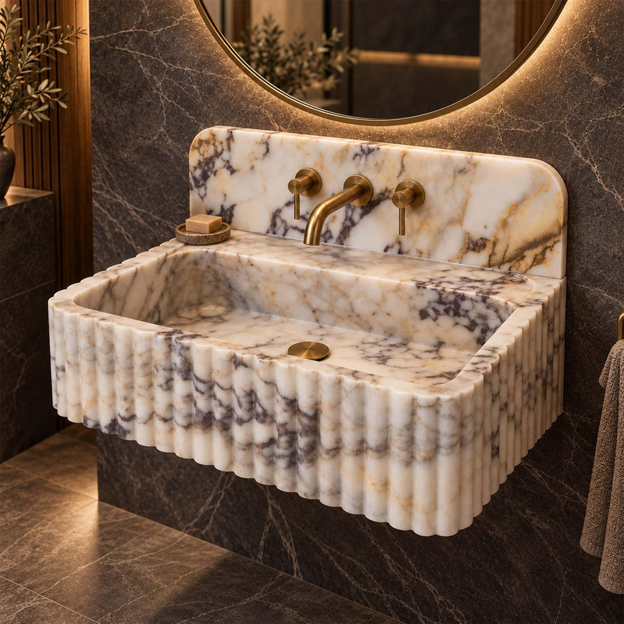Calacatta Gold fluted vanity sink with rounded backsplash styled in a designer powder room