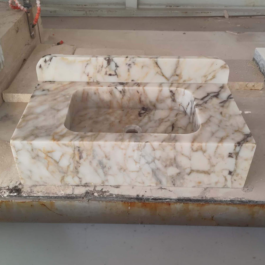 Front view of a hand-carved Calacatta Gold smooth console sink