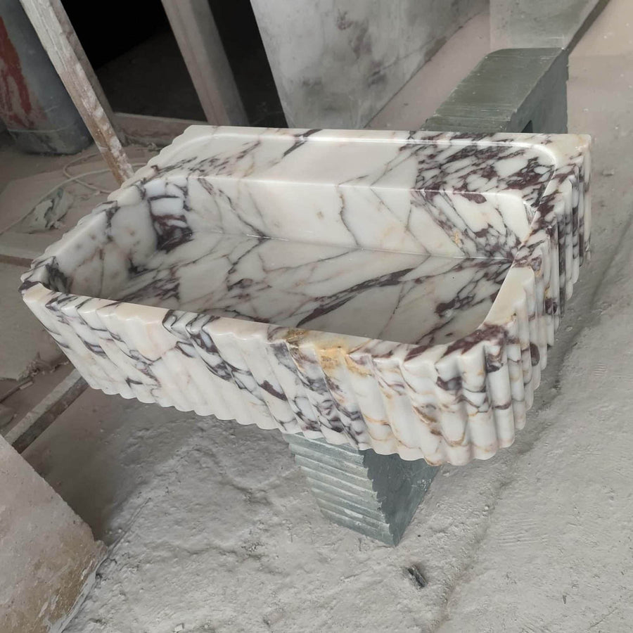 Top view of the deep integrated basin of a Calacatta Viola fluted floating sink