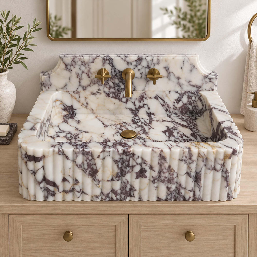 Side view of a solid Calacatta Viola fluted console sink