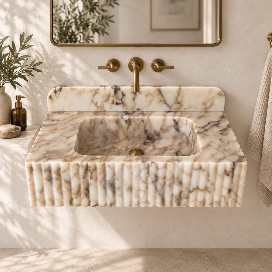 Calacatta Gold fluted marble sink with rounded backsplash styled in a designer powder room