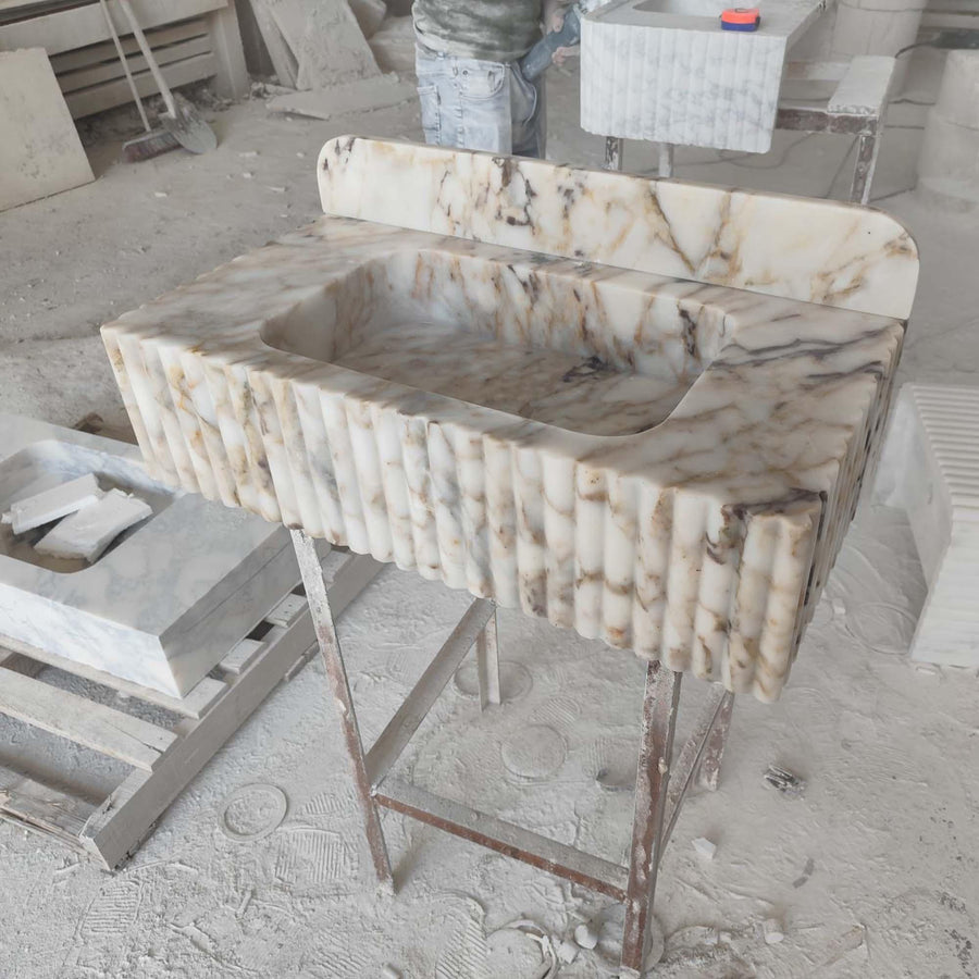 Top view of the deep integrated basin of a Calacatta Gold fluted floating sink