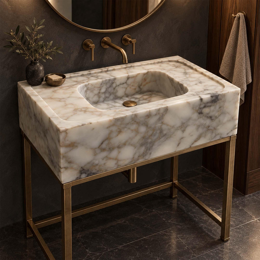 Calacatta Gold smooth marble sink with wide deck on a custom brass vanity stand