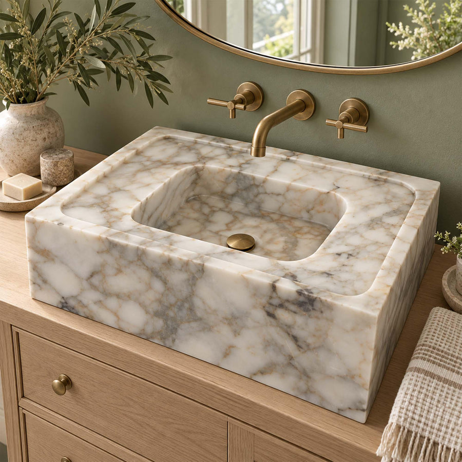 Natural stone smooth floating sink in Calacatta Gold with brass fittings
