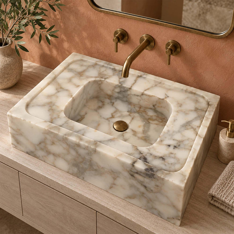Calacatta Gold smooth marble sink with wide deck on a wood vanity cabinet