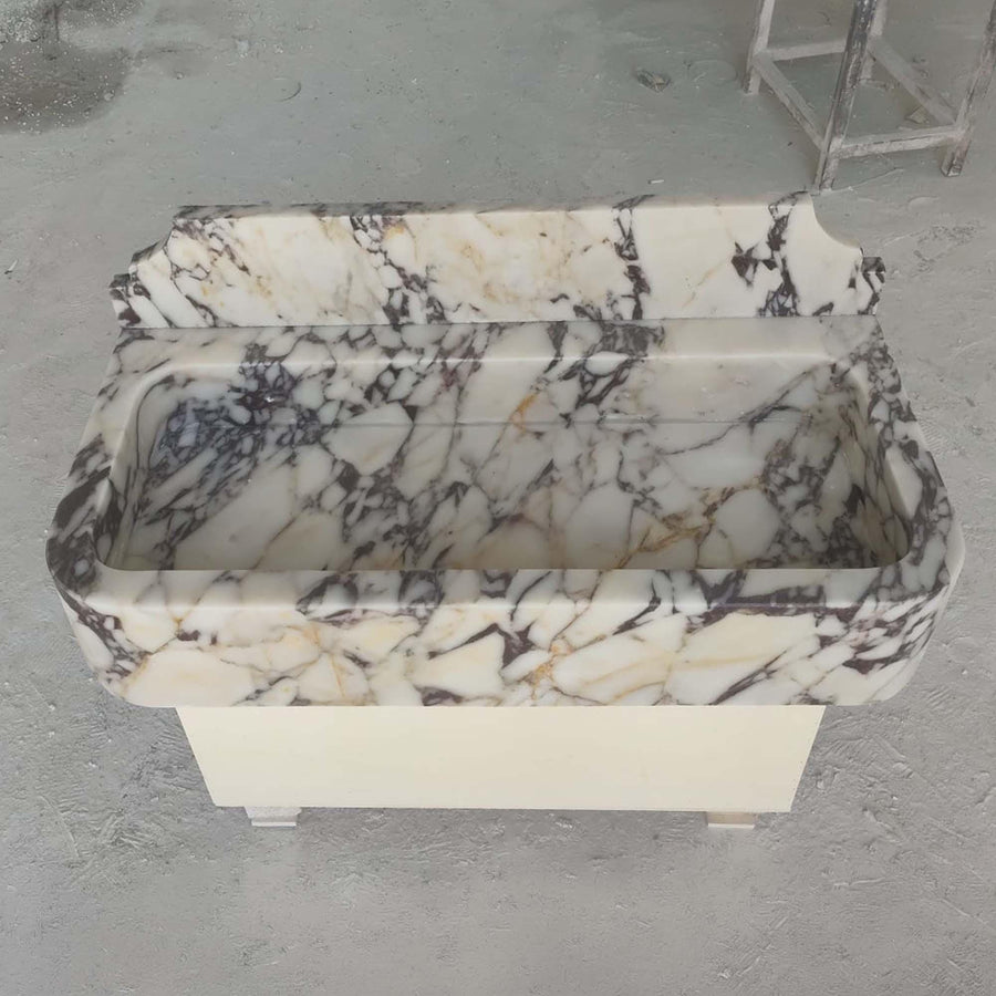 Calacatta Viola smooth console sink with decorative backsplash in a luxury bathroom