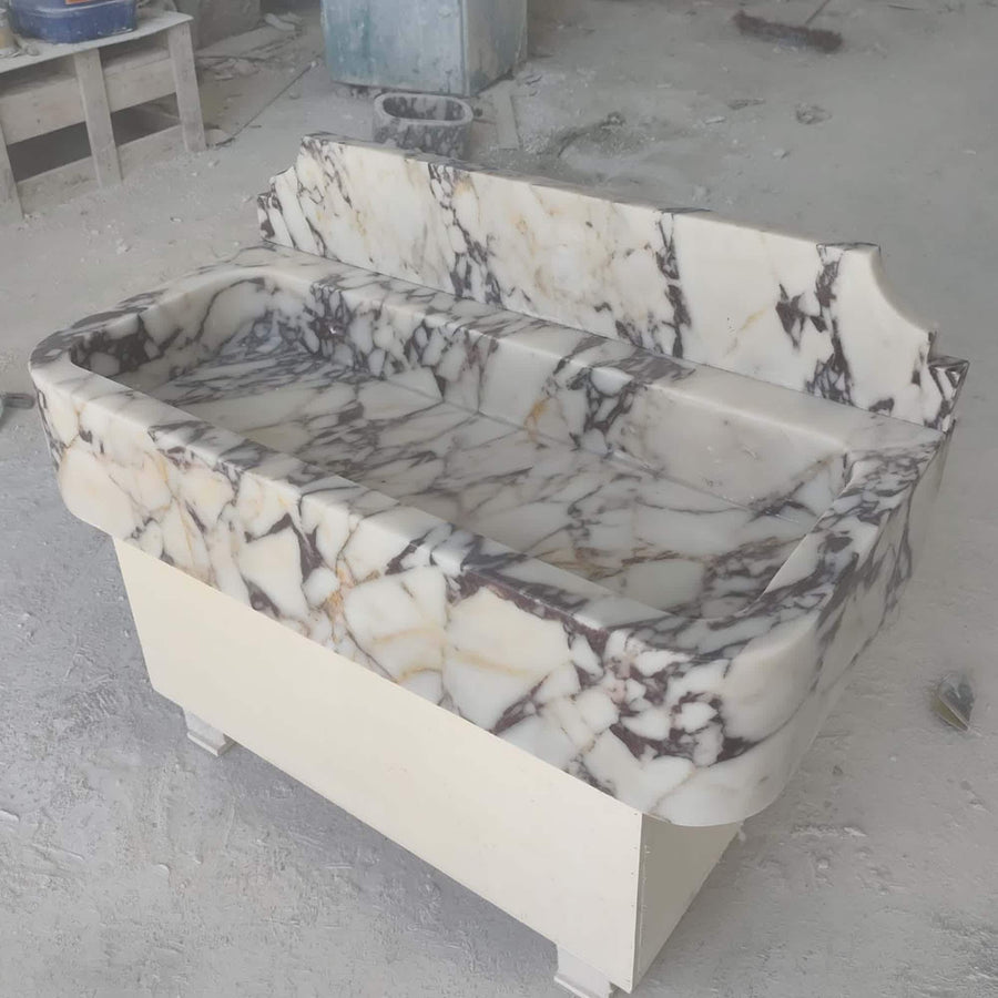 Side view of a solid Calacatta Viola smooth console sink