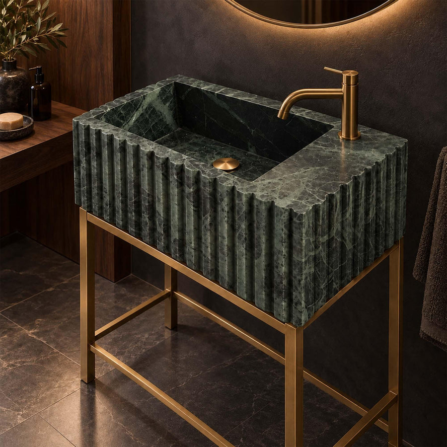 Green marble fluted vanity sink with single faucet hole on a custom brass vanity stand