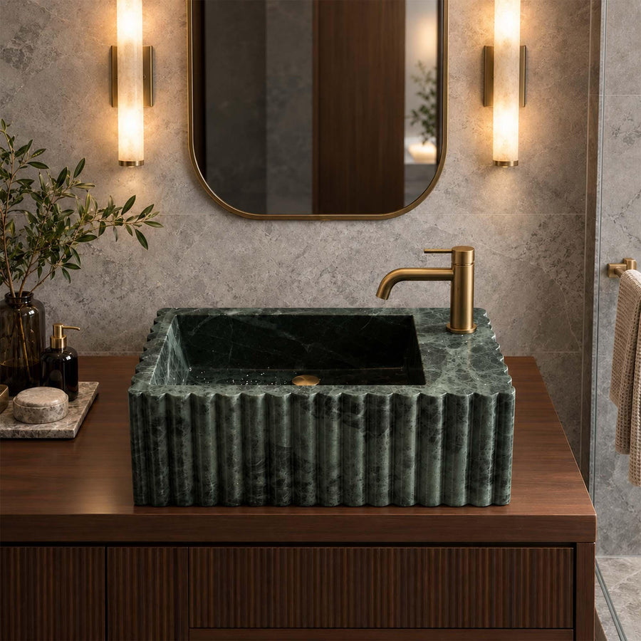 Green marble fluted vanity sink with single faucet hole on a wood vanity cabinet