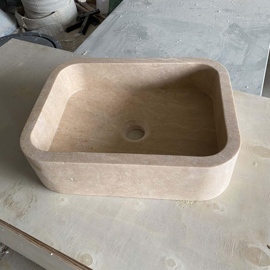 Side view of a solid Beige Travertine rounded floating sink