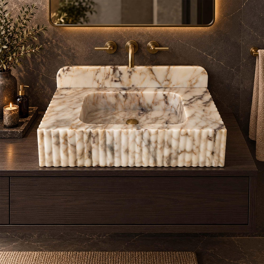 Calacatta Gold fluted marble sink with rounded backsplash in a luxury bathroom