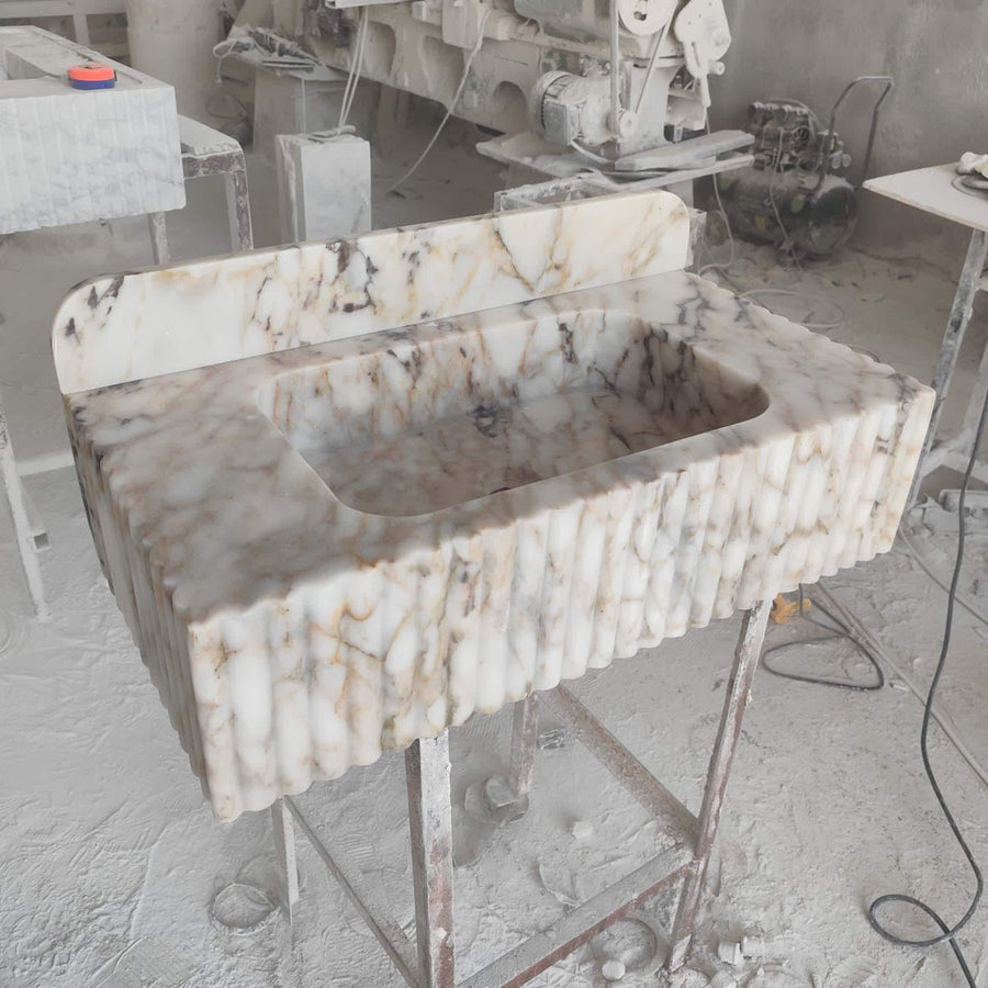 Close-up of natural veining on a Calacatta Gold fluted floating sink