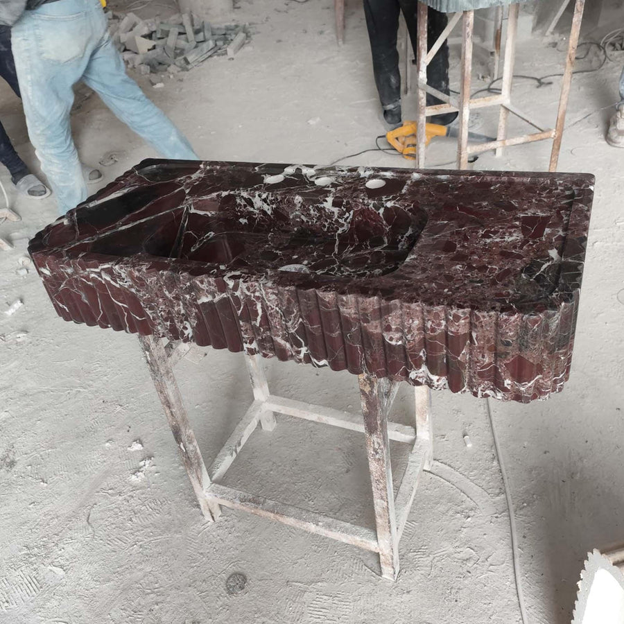 Rosso Levanto fluted console sink showing the drilled faucet holes