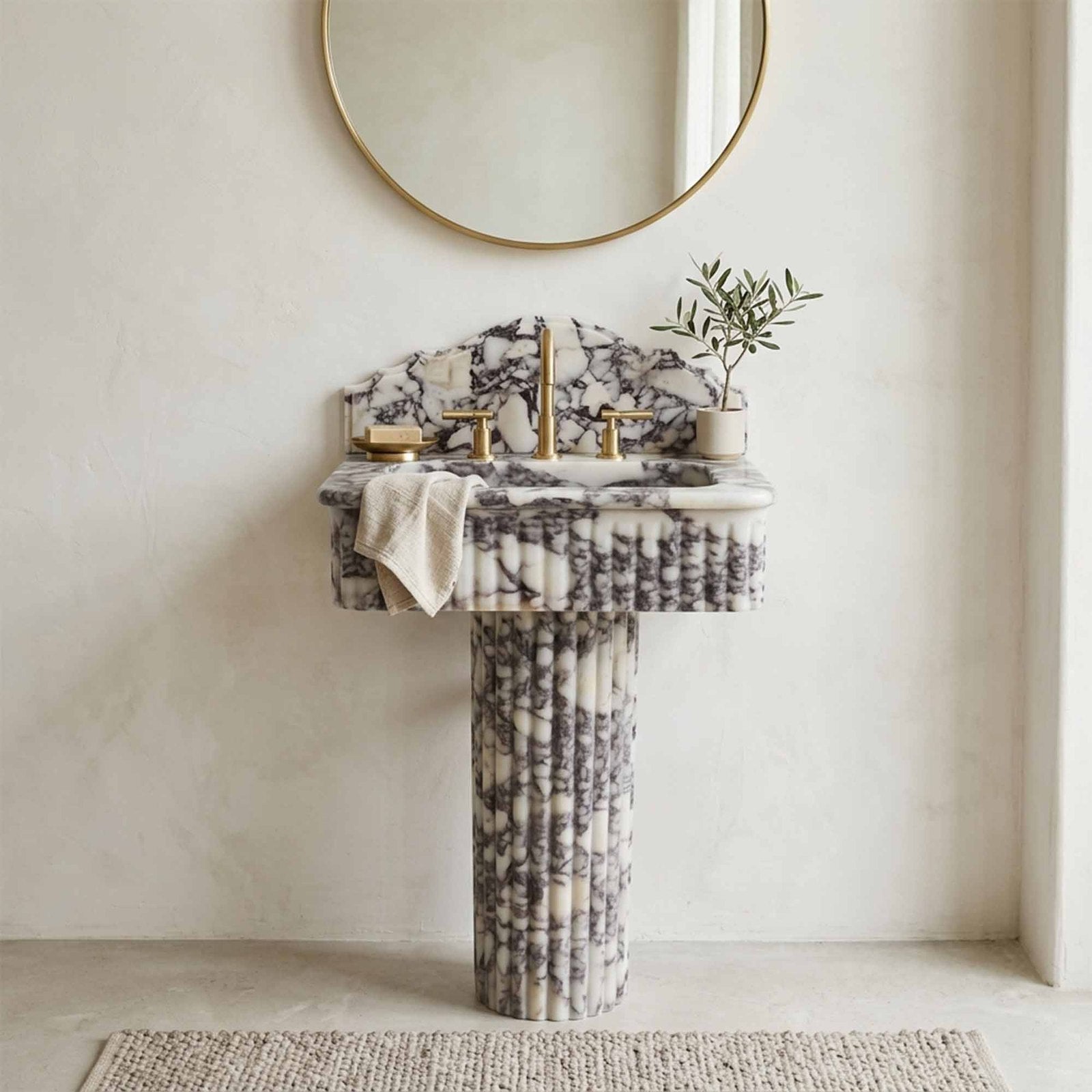 Marble pedestal sink against plaster wall in minimalist bathroom