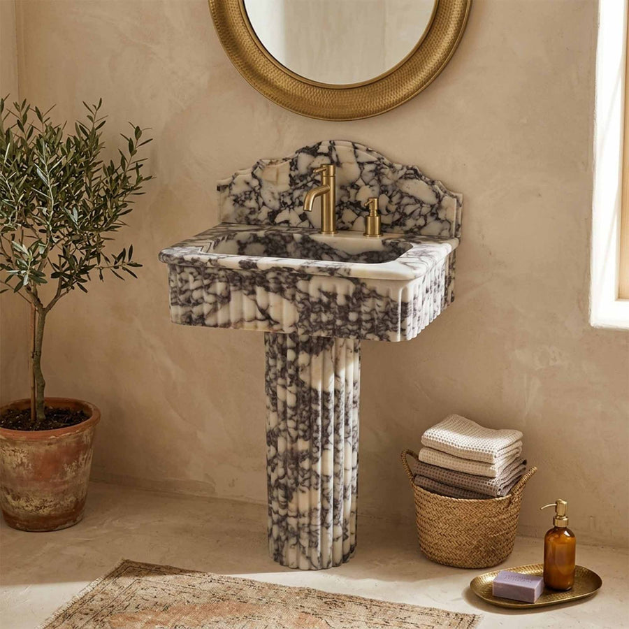 Marble pedestal sink with single handle faucet and olive tree