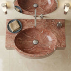 This is not a standard sink. It is a hand-carved red marble oval sink, sculpted from a single block of natural stone and designed as a seamless integrated basin and countertop.