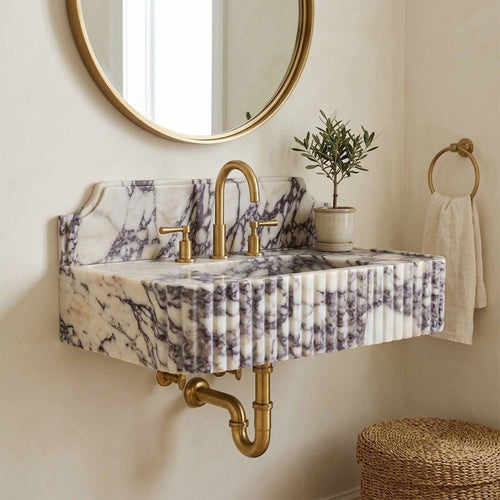 Marble sink with backsplash and exposed brass wall plumbing