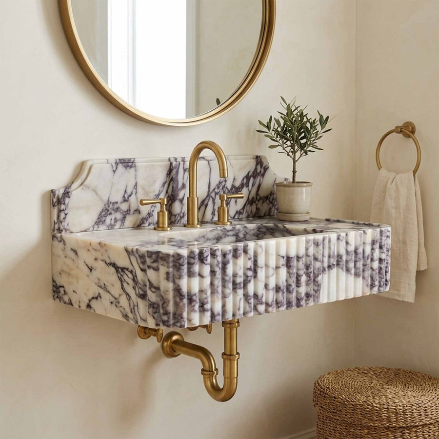 Marble sink with backsplash and exposed brass wall plumbing