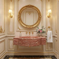 Luxurious bathroom with pink marble sink, gold fixtures, and decorative mirror.