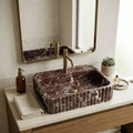 This is not a standard sink. It is a hand-carved dark marble fluted sink, sculpted from a single block of natural stone and designed as a seamless integrated sink and countertop.
