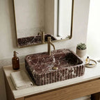 This is not a standard sink. It is a hand-carved dark marble fluted sink, sculpted from a single block of natural stone and designed as a seamless integrated sink and countertop.