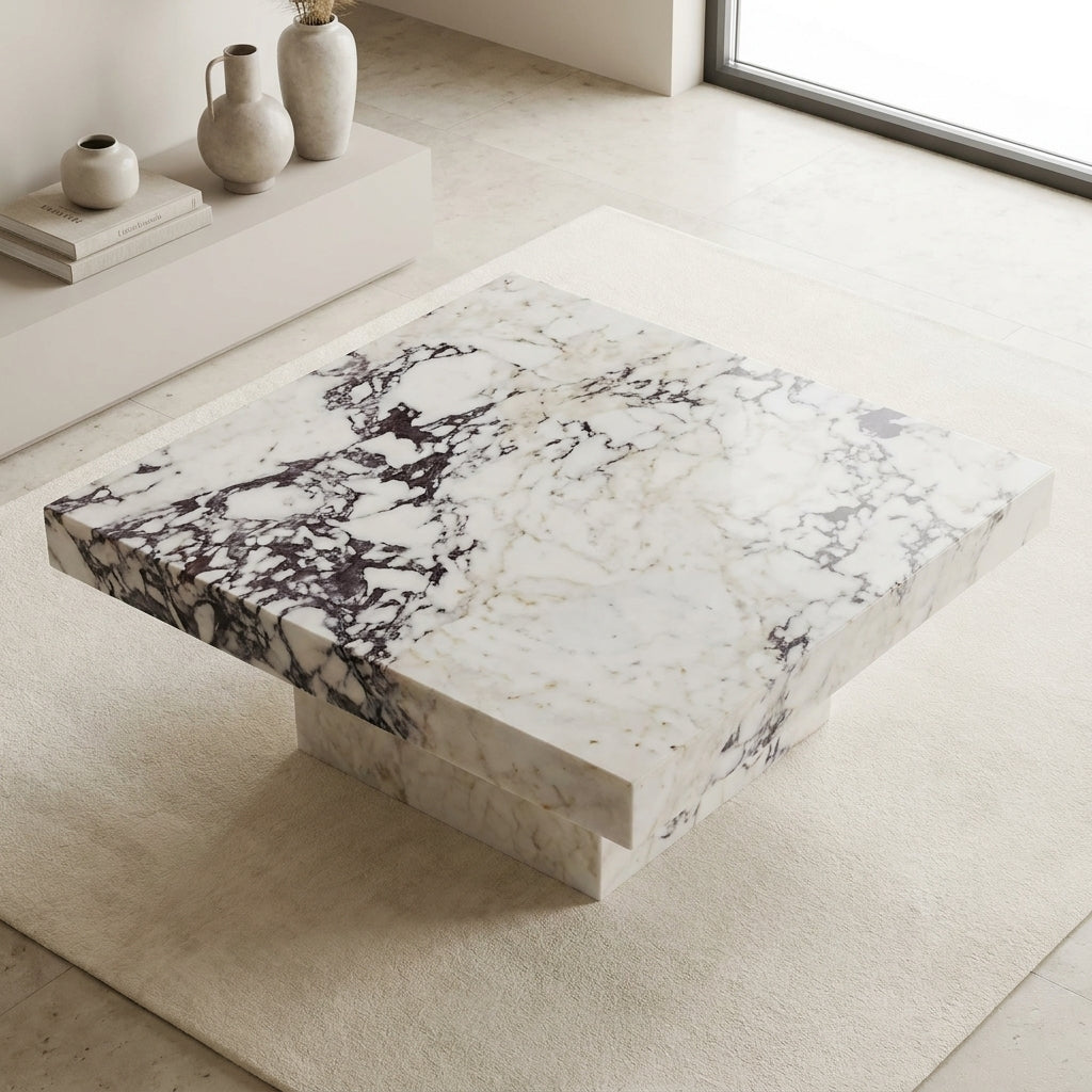 Marble coffee table in a minimalistic room with light-colored floor and walls.