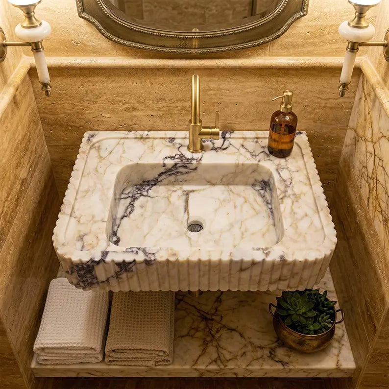 Marble sink with gold faucet in a bathroom setting