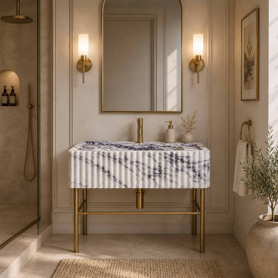 Marble sink with faucet and a brass stand  in a bathroom setting