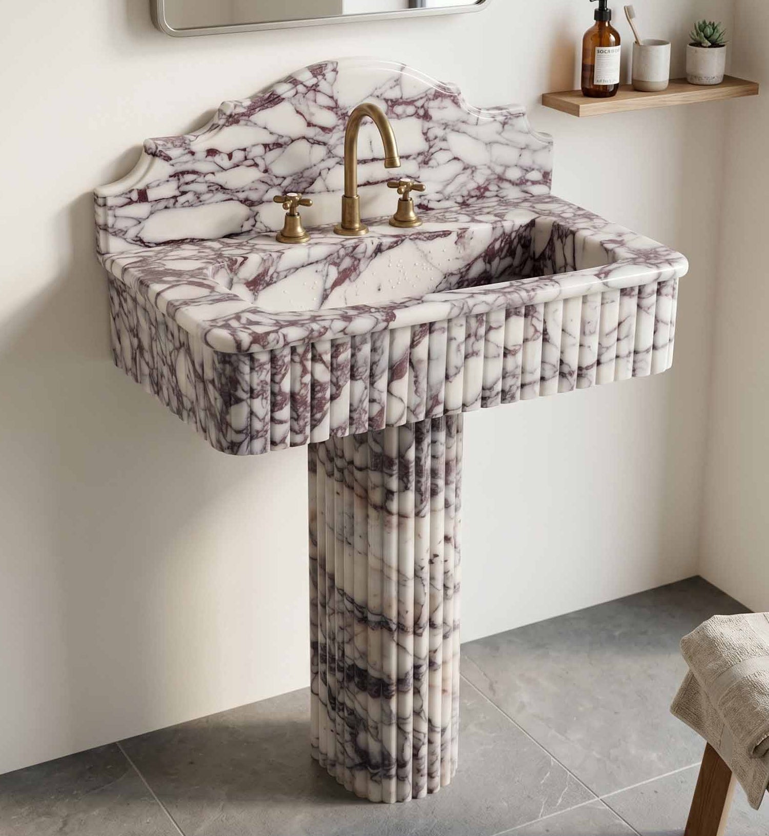 Marble pedestal sink with gold faucet in a bathroom setting