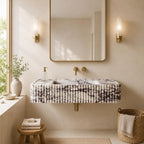 A modern floating bathroom vanity with a ribbed white marble-look front, gold faucet hardware, a large rectangular mirror, and two warm wall sconces in a softly styled bathroom setting.