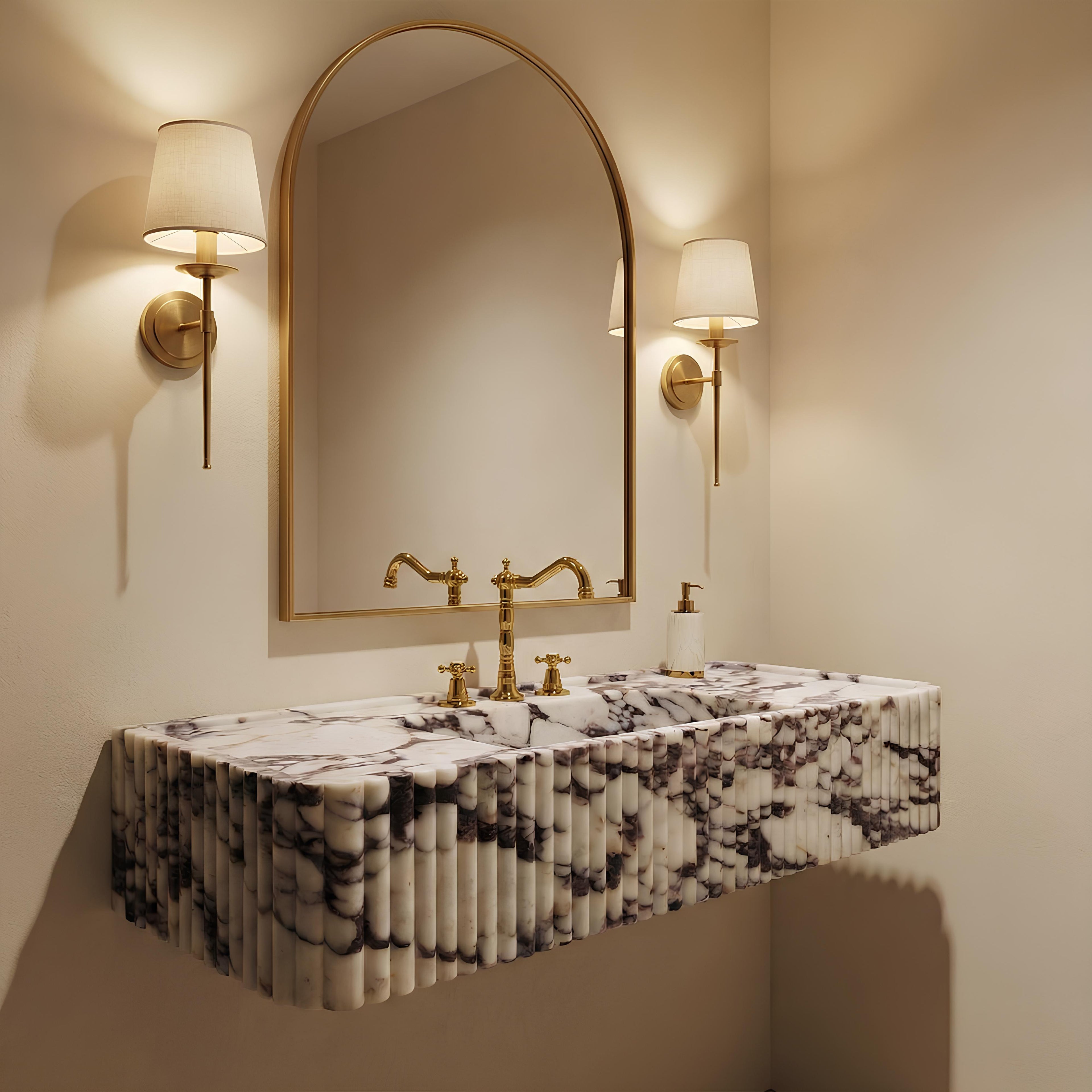 Bathroom vanity with marble countertop, gold fixtures, and wall-mounted lamps.