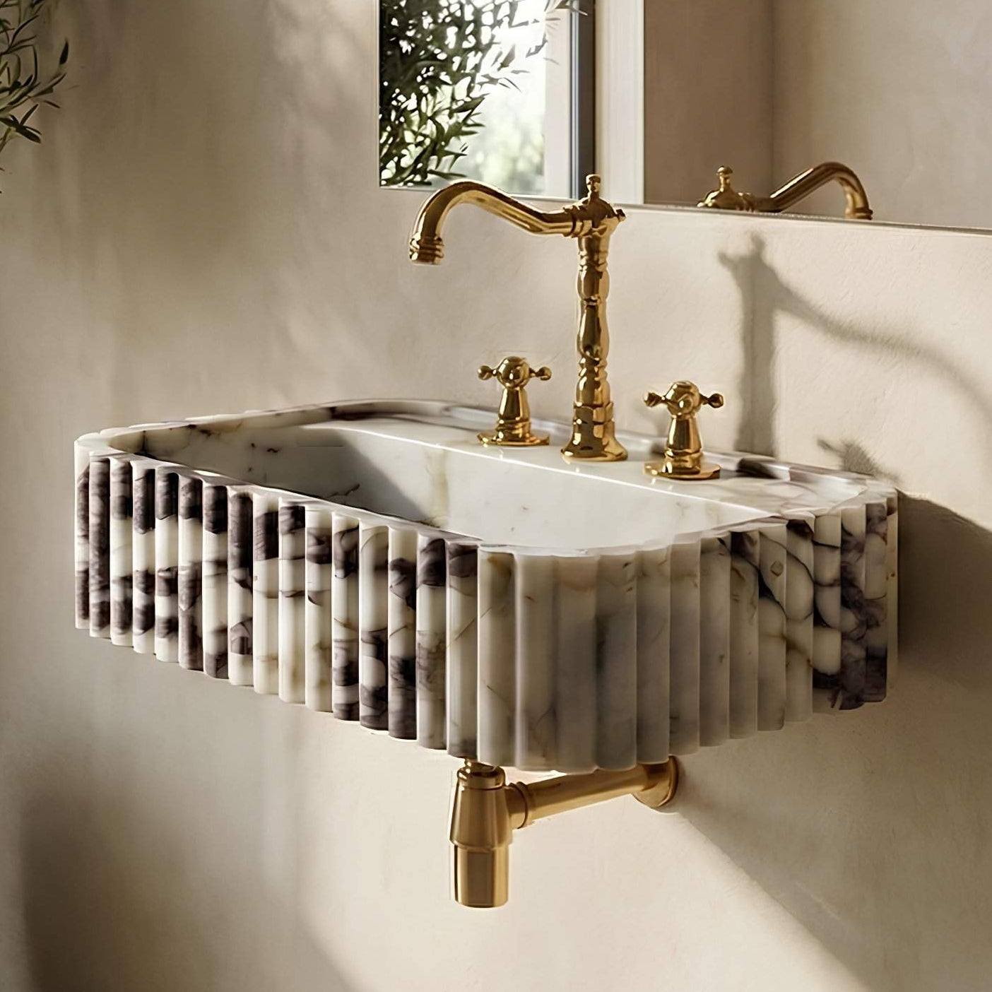 Marble sink with gold fixtures in a bathroom setting